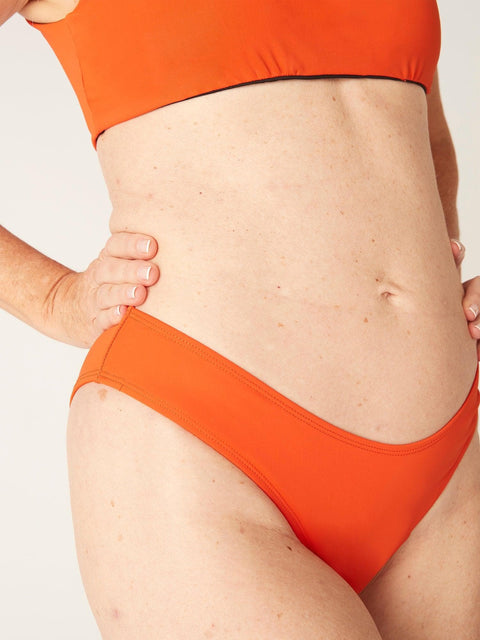 Modibodi Recycled Swimwear Brazilian Brief Sunset Orange|ModelName: Jane 10/S